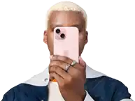 Egy ember az iPhone 15-öt az arca elé tartva rejti el a személyazonosságát.