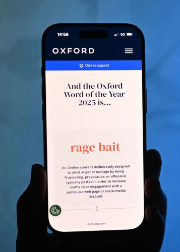 Okostelefon képernyőjén az Oxford Word of the Year 2025: "rage bait" definíciója látható. Oxford, rage bait, szó definíció, online tartalom, mobiltelefon, hír.